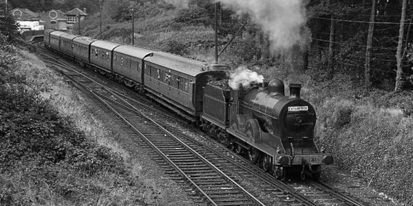 An old train travels across the contry side.